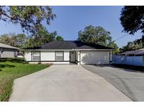 Charming single-story home featuring a spacious driveway, manicured lawn, and an attached two-car garage at 5435 Birchwood Rd, Spring Hill, FL 34608