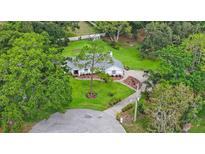 Charming single-story home with beautiful landscaping and mature trees in a well-maintained front yard at 5933 Carina Trce, Wesley Chapel, FL 33545