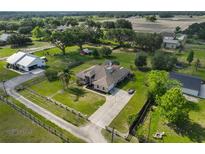 Aerial view of a charming single-Gathering home with a spacious yard and long driveway surrounded by mature trees at 611 Robinson Oaks Ln, Plant City, FL 33567
