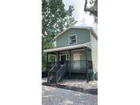 Charming two-story home features a welcoming front porch with sleek, modern railings at 7152 Sandy Ln, Wesley Chapel, FL 33544