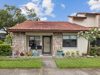 Charming single-story home with a red tile roof, brick accents, and a cozy front porch and well-maintained landscaping at 7360 Ulmerton Rd # 18A, Largo, FL 33771