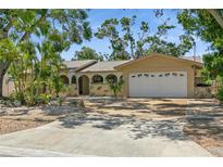 Charming single-story home with a two-car garage, arched entry and tropical landscaping at 8020 28Th N Ave, St Petersburg, FL 33710