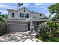 Charming two-story home with well-manicured lawn and a gray color scheme and a covered front porch at 8095 35Th Ave N, St Petersburg, FL 33710