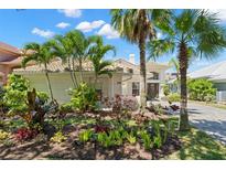 Charming single-story home featuring a well-manicured lawn with lush tropical landscaping and a tile roof at 8708 Laurel N Dr, Pinellas Park, FL 33782