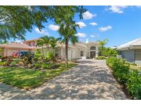 Charming home with lush landscaping, brick driveway, and inviting facade at 8708 Laurel N Dr, Pinellas Park, FL 33782