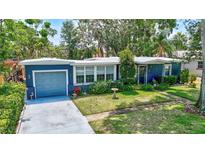 Charming blue single-Gathering home featuring a lush green lawn and well-maintained landscaping at 1115 45Th N St, St Petersburg, FL 33713