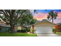 Charming single-Gathering home featuring a well-manicured lawn, mature trees, and an attached two-car garage at 11510 92Nd Way, Largo, FL 33773