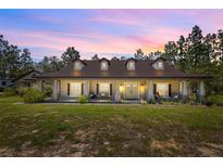 Stunning exterior view of a home with a charming front porch and manicured lawn at 12090 Thames Ave, Weeki Wachee, FL 34614