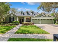 Charming one-story home featuring a three-car garage, well-manicured lawn, and attractive landscaping at 16039 Ternglade Dr, Lithia, FL 33547