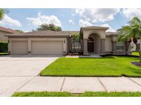 Charming home with a well-manicured lawn, large windows, and a three car garage at 18518 Bittern Ave, Lutz, FL 33558