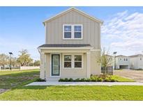 Inviting two-story home featuring a quaint front porch, manicured lawn, and modern architectural details at 2039 Amelia Bay Pl, Valrico, FL 33596