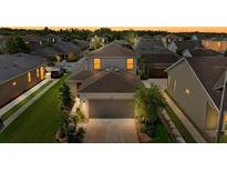 Charming two-story home boasts a well-manicured lawn and attached two-car garage in a neatly organized residential area at 32718 Harmony Oaks Dr, Wesley Chapel, FL 33545