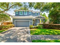 Charming two-story home with a well-manicured lawn, mature trees, and a gray exterior paint scheme at 3714 W San Juan St, Tampa, FL 33629