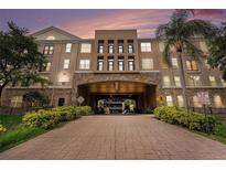 Condo building with landscaped entrance and parking garage access on a sunny day at 4221 W Spruce St # 2104, Tampa, FL 33607