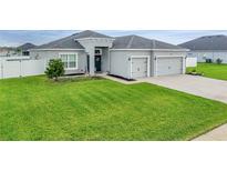 Beautiful home with a lush green lawn, gray exterior, and a two-car garage at 4435 Devinshire Fields Loop, Plant City, FL 33567