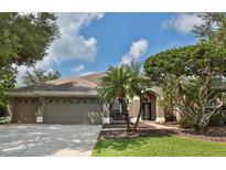 Lovely single-story home with a well-manicured lawn, mature landscaping, and a three-car garage at 4808 Jewell Ter, Palm Harbor, FL 34685