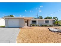 Charming single-story home featuring a well-maintained front yard and attached garage at 4842 Odyssey Ave, Holiday, FL 34690