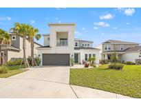 Two story home featuring manicured lawn, elegant balcony, two-car garage, and mature palm trees at 5810 Fieldmoor Ct, Palmetto, FL 34221
