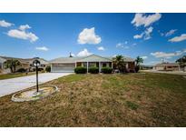 Charming single-story home featuring a well-maintained lawn and screened garage at 801 Oakmont Ave, Sun City Center, FL 33573