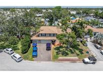 A charming two-story home with a well-manicured front yard and mature trees providing ample shade at 8263 132Nd St, Seminole, FL 33776