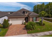Charming single-story home with a brick driveway, lush landscaping, and a two-car garage at 19652 Ship Wheel Way, Land O Lakes, FL 34638