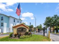 Community entrance featuring the Coquina Key sign, flag, and gate at 3866 Mariner Dr, St Petersburg, FL 33705