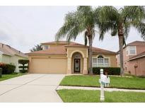 Well-maintained home with a two-car garage, arched entryway, and lush lawn and landscaping at 4535 Gateway Blvd, Wesley Chapel, FL 33544