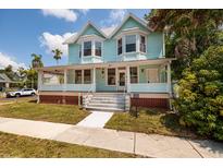 Charming light blue two-story home with a large porch and well-manicured lawn at 457 8Th N Ave, St Petersburg, FL 33701