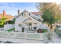 Charming two-story home featuring a white picket fence and a cozy front porch with tasteful decor at 634 6Th N St, St Petersburg, FL 33701