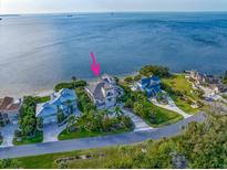 Stunning waterfront home with lush landscaping and circular driveway in a serene coastal setting at 812 Point Seaside Dr, Crystal Beach, FL 34681
