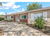 Charming single-story home with brick accents, lush landscaping, and a beautifully paved driveway at 9810 N 53Rd St, Temple Terrace, FL 33617