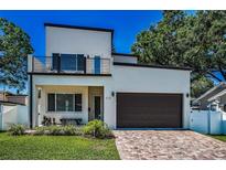 Modern two-story home with a balcony, brick driveway, and a well-manicured front lawn at 112 W Sligh Ave, Tampa, FL 33604