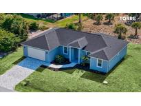 New construction home featuring a two car garage, landscaped yard, and a covered entryway at 14024 Wenzel Ave, Port Charlotte, FL 33981