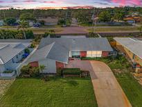 Charming single-story home with a well-maintained lawn, long driveway, and a classic brick facade at 14341 Passage Way, Seminole, FL 33776