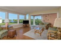 Bright living room with floor-to-ceiling windows and stylish furnishings overlooking lush landscape at 1500 Sunset Rd # C10, Tarpon Springs, FL 34689
