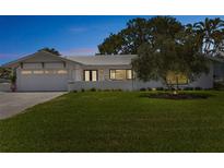 Charming single-story home with a well-manicured lawn, attached garage, and freshly painted white exterior at 2084 Massachusetts Ne Ave, St Petersburg, FL 33703