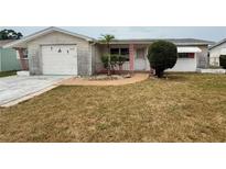 Charming single-story home with a well-maintained front yard and decorative brick pathway at 3035 Coldwell Dr, Holiday, FL 34691