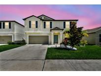 Charming two-story home boasts a well-manicured lawn and a welcoming entrance at 5410 Amaryllis Garden St, Apollo Beach, FL 33572