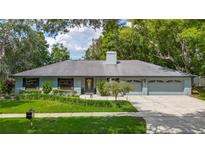 Charming single-story home with well-manicured lawn, mature trees and a two car garage at 1014 Sylvia Ln, Tampa, FL 33613