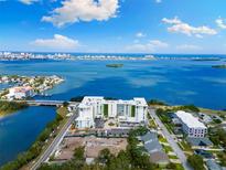 Breathtaking aerial view of the pristine white condominium complex overlooking the beautiful bay waters and distant city at 1020 Sunset Point Rd # 410, Clearwater, FL 33756
