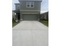 Two-story home featuring a large driveway and a two-car garage at 10448 Ladybug Cv, Parrish, FL 34219