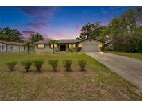 Charming single-story home with a well-manicured lawn and a cozy, inviting appeal in the evening light at 16112 N 15Th St, Lutz, FL 33549