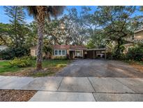 Charming single-story home features a large driveway, carport, mature landscaping and mature shade trees at 1753 San Mateo Dr, Dunedin, FL 34698