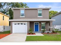 Charming two-story home with a bright blue front door and well-manicured landscaping at 1880 Fuller Dr, Clearwater, FL 33755