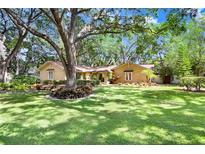 Charming single-story home with mature trees, lush landscaping, and a well-maintained lawn at 2503 Victarra Cir, Lutz, FL 33559