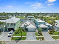 An aerial view shows waterfront homes with lush landscaping, paver driveways and the canal system in the neighborhood at 574 Bimini Bay Blvd, Apollo Beach, FL 33572