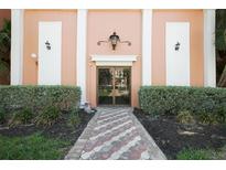 Welcoming building entrance with a classic lamp and mature landscaping at 6960 20Th N Ave # 203B, St Petersburg, FL 33710