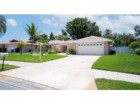 Charming single-story home with well-manicured lawn, mature landscaping, and a two-car garage at 8060 Canterbury Cir, Seminole, FL 33777