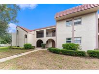 Charming condo featuring well-maintained landscaping, a red tile roof, and inviting archway at 9700 Starkey Rd # 312, Seminole, FL 33777
