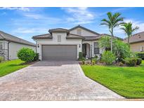 Beautiful home featuring a paved driveway, a two-car garage, and lush landscaping at 16723 Blackwater Ter, Bradenton, FL 34202